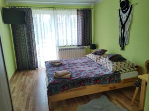 a bedroom with two beds and a window at Pokoje Goscinne U Janki in Murzasichle