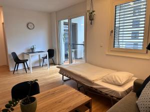 een woonkamer met een bed en een tafel bij 2-Zimmer Wohnung in Oberlaa mit privatem Tiefgaragen Platz in Wenen