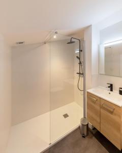 una doccia in vetro in un bagno con lavandino di Villa de luxe au Pyla avec piscine en bordure du golf d'Arcachon, 5 chambres a La Teste-de-Buch