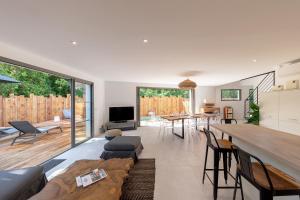 un soggiorno con un divano e un tavolo di Villa de luxe au Pyla avec piscine en bordure du golf d'Arcachon, 5 chambres a La Teste-de-Buch