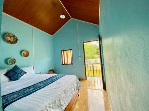 a bedroom with a bed and a blue wall at Tay Farmhouse in Ha Giang