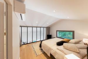 una camera da letto con due letti e una grande finestra di Villa de luxe au Pyla avec piscine en bordure du golf d'Arcachon, 5 chambres a La Teste-de-Buch Altre 21 foto