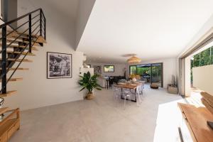 un soggiorno con scala e una sala da pranzo di Villa de luxe au Pyla avec piscine en bordure du golf d'Arcachon, 5 chambres a La Teste-de-Buch