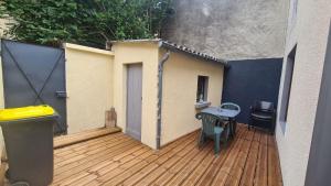 eine Terrasse mit einem Tisch und Stühlen auf einer Holzterrasse in der Unterkunft Petite maison cosy wifi avec terrasse in Montigny-le-Gannelon
