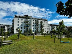 een groot wit gebouw met een park ervoor bij 2-Zimmer Wohnung in Oberlaa mit privatem Tiefgaragen Platz in Wenen