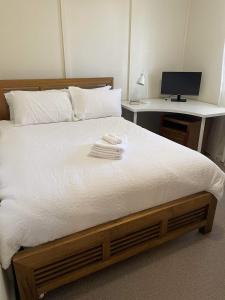 Schlafzimmer mit einem Bett, einem Schreibtisch und einem Computer in der Unterkunft Blissful Mountain Stay in Katoomba