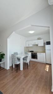 a kitchen with a table and chairs in a room at Apartmani SKY 123 in Brčko +17 photos