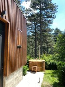 a wooden hot tub sitting next to a house at National Park Sauna Retreats - Villa 68 Pines in Kaludjerske Bare