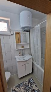 ein kleines Bad mit einem Waschbecken und einem WC in der Unterkunft Apartmani SKY 1 2 3 in Brčko