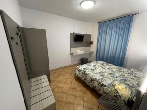 Agriturismo Parmoleto في Montenero: غرفة نوم صغيرة بها سرير وتلفزيون