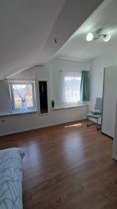 ein leeres Wohnzimmer mit einem Bett und zwei Fenstern in der Unterkunft Apartmani SKY 1 2 3 in Brčko