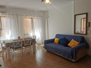 a living room with a blue couch and a table at La Piazzetta in Nettuno