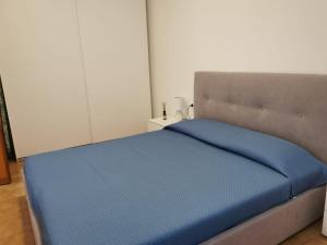 um quarto com uma cama com um cobertor azul em La Piazzetta em Nettuno
