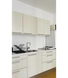 una cocina blanca con armarios blancos y fregadero en ApartmentInCopenhagen Apartment 1556, en Copenhague