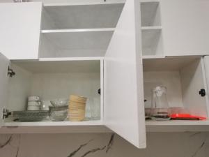 a white cabinet with dishes and bowls in it at Transient San Pablo Lagun in San Pablo