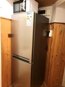 lodówka ze stali nierdzewnej w kuchni z drewnianymi szafkami w obiekcie Rooms by Kino Femina w Warszawie