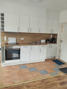 a kitchen with white cabinets and a stove top oven at Ferienwohnungen-Oberkochen.de Stadtherberge Sperberstraße in Oberkochen