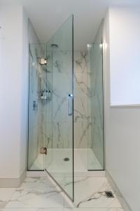a glass shower stall in a bathroom with marble at Modern Comforts 2 bed 2 bath Inner City in Christchurch