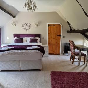 a bedroom with a bed and a table and a chair at Castle Hill Cottage on a Scheduled Monument in Kenilworth