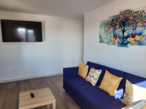 a living room with a blue couch and a tv at PISOS TURISTICOS 3M in San Andrés del Rabanedo