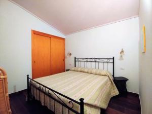 a bedroom with a bed with a wooden door at "Ruby Seadragon Holiday Home" a 80 m dal mare con giardino recintato P5584 in Villaputzu