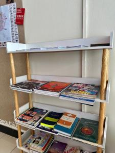 uno scaffale con riviste e libri sopra di Swing & Pillows @ Malabar a George Town