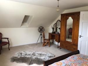 a bedroom with a bed and a desk and a fan at Country Retreat Sleeps 2 with Horses Ducks & more in Holyhead