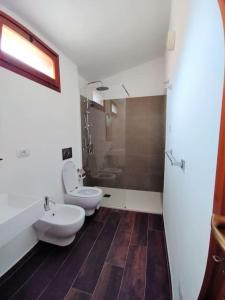 a bathroom with two toilets and a sink at "Ruby Seadragon Holiday Home" a 80 m dal mare con giardino recintato P5584 in Villaputzu