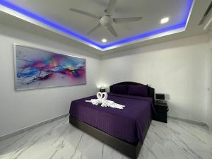 a bedroom with a purple bed with a ceiling fan at STUNNING BEACHFRONT VIEW LUXURIOUS Apartment 30 in Jomtien Beach