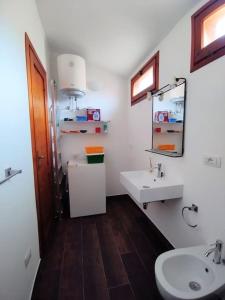 a bathroom with a sink and a toilet and a mirror at "Ruby Seadragon Holiday Home" a 80 m dal mare con giardino recintato P5584 in Villaputzu