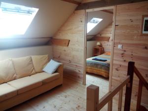 ein Wohnzimmer mit einem Sofa und einem Bett in der Unterkunft Le Jardin Enchanteur, chaleureuse maison d'hôtes calme et accueillante in Lopérec