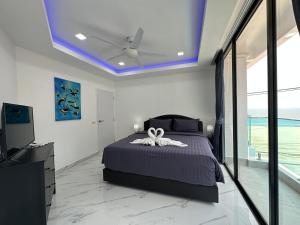 a bedroom with a bed with a ceiling fan at STUNNING BEACHFRONT VIEW LUXURIOUS Apartment 30 in Jomtien Beach
