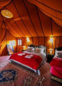 a bedroom with a bed in a tent at Merzouga Top Luxury Camp in Merzouga