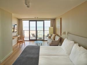 une chambre d'hôtel avec un lit et une vue sur l'océan dans l'établissement Hotel de Blanke Top, à Cadzand-Bad 37 autres photos