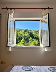 a bedroom with a window with a view of a forest at Apartmani Luka in Korčula