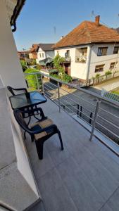 une chaise assise au bord d'un balcon dans l'établissement Apartman SKY 4, à Brčko