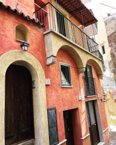 un edificio arancione con un balcone e due porte di Cisternone Suites a Formia