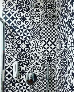 un bagno con piastrelle bianche e nere su un muro di Cisternone Suites a Formia