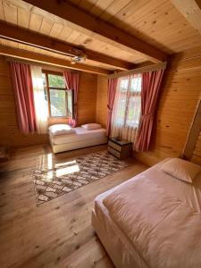 a bedroom with a bed and windows in a cabin at Abduloğlu Butik Otel in Çamlıhemşin