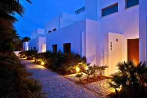 a large white building with palm trees and lights at Sao Rafael Holidays in Albufeira