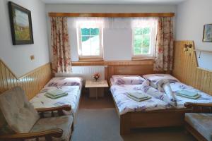 ein Zimmer mit 2 Betten und einem Stuhl darin in der Unterkunft Penzion u Veselých in Pec pod Sněžkou