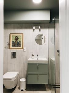 a bathroom with a sink and a toilet and a mirror at Art space at Old Town in Gdańsk