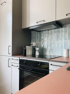 a kitchen with a black oven and white cabinets at Art space at Old Town in Gdańsk