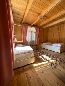 a bedroom with two beds in a wooden house at Abduloğlu Butik Otel in Çamlıhemşin