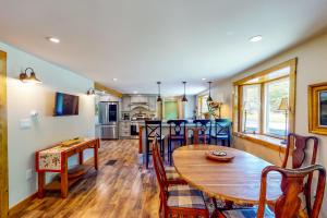 Coos Canyon Lodge : مطبخ وغرفة معيشة مع طاولة وكراسي خشبية
