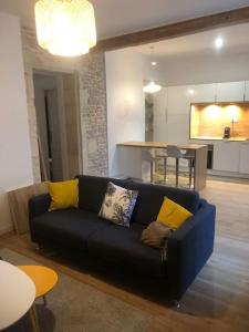 ein Wohnzimmer mit einem blauen Sofa und gelben Kissen in der Unterkunft Nimes centre ville appartement cosy 2 chambres in Nîmes