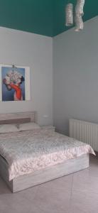 1 dormitorio con 1 cama con una foto en la pared en Гостевой дом в центре города en Kobuleti