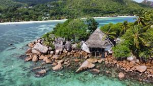 uma ilha no oceano com pedras na água em Chauve Souris Relais em Anse Volbert Village