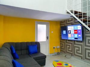 sala de estar con sofá y TV de pantalla plana en 1 bedrm Apt wi-fi rooftop pool en Mombasa