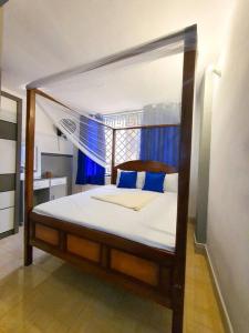 1 dormitorio con cama con dosel y almohadas azules en 1 bedrm Apt wi-fi rooftop pool en Mombasa